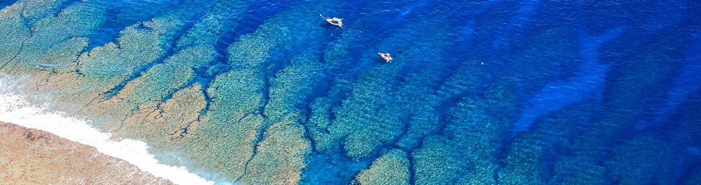 Cristalline blue lagoon waters of West Reunion islan, white sand beach and Saint Gilles City