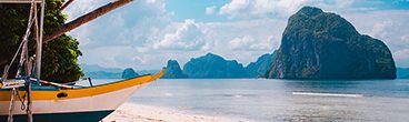 Banca boat on shore under palm trees.Tropical island scenic landscape. El-Nido, Palawan
